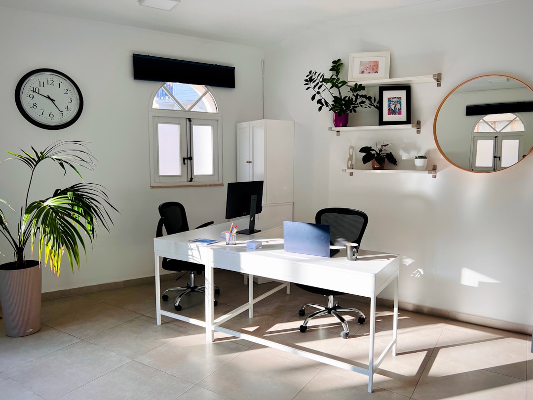 A bright and modern desk with only a few essential, high-quality items like a laptop and notebook, illustrating a professional, focused, and lean approach to work.