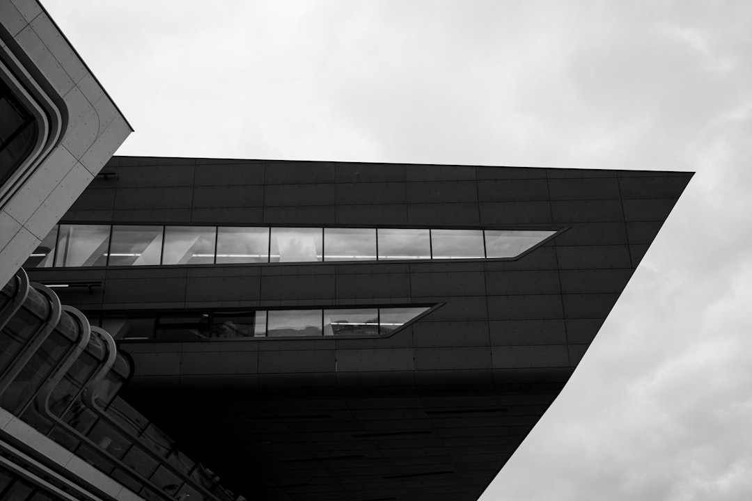 A sleek, modern architectural structure seamlessly integrated with or standing next to a classic, traditional brick building, symbolizing innovation in the real estate industry.